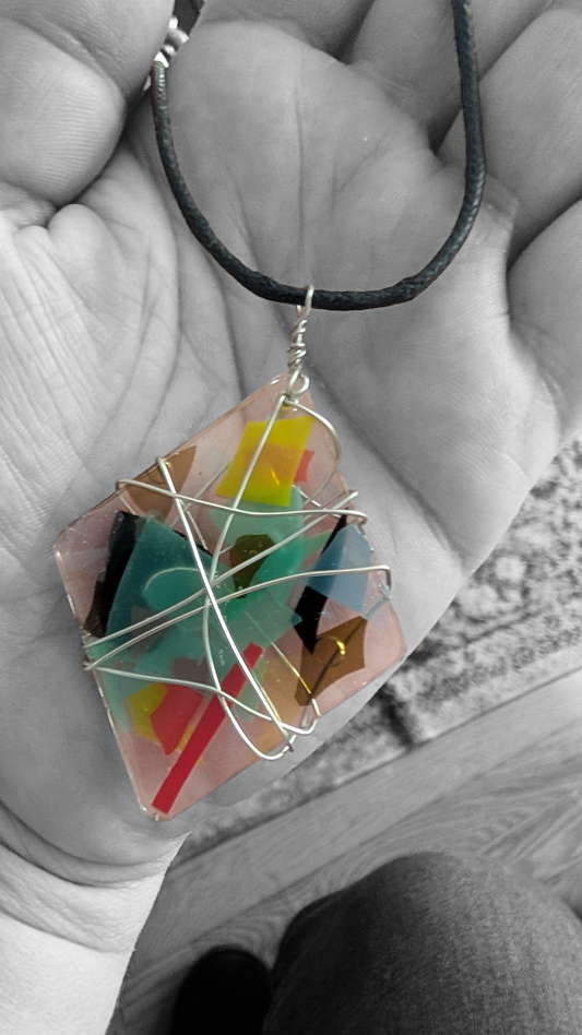 Diamond shaped broken encased glass necklace on black cord